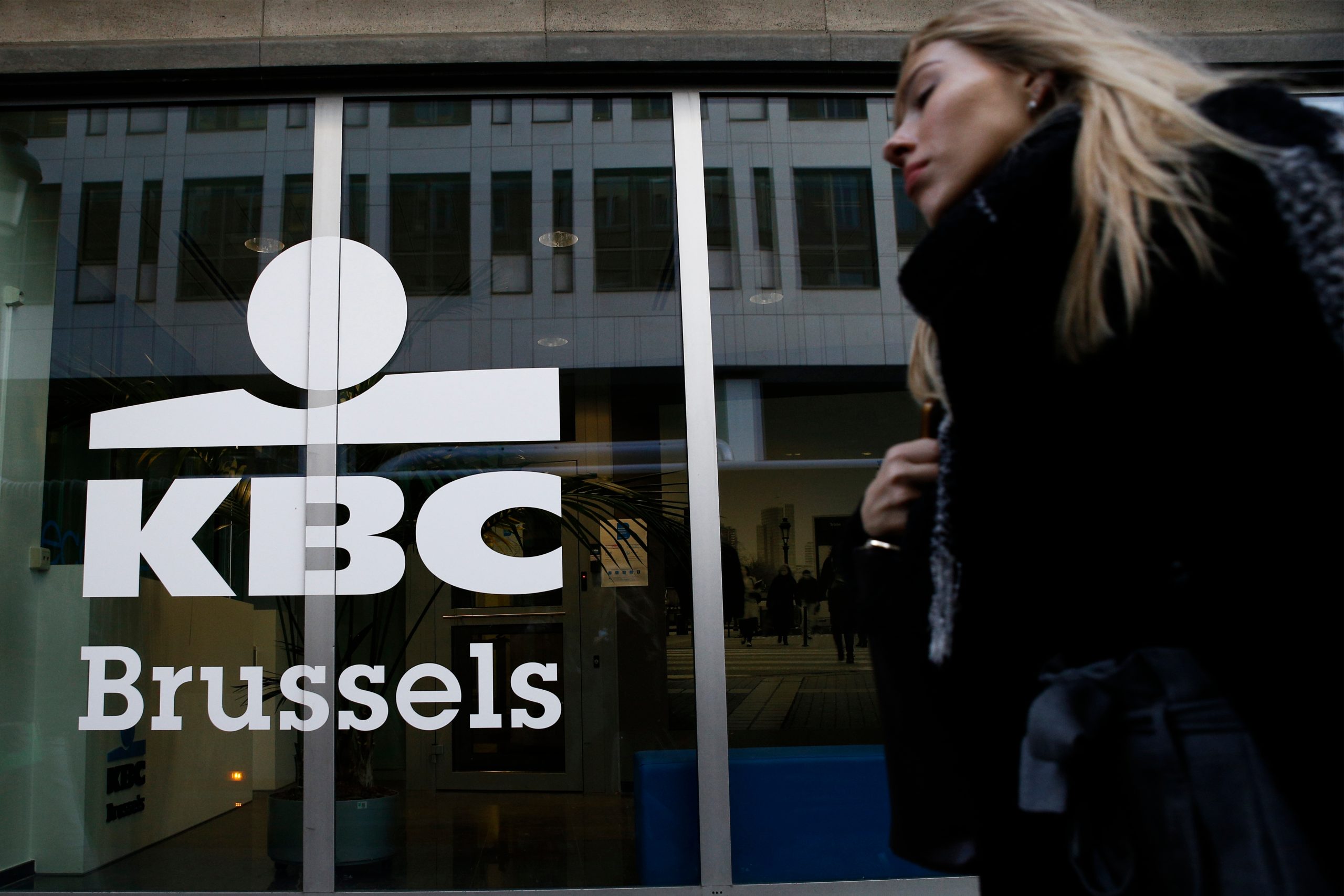 Frau läuft vor Gebäude der KBC-Bank