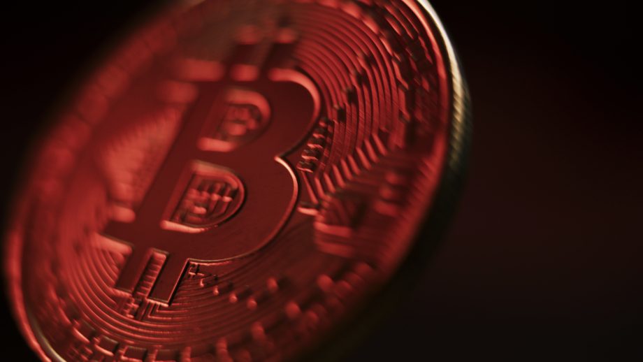 Eine rötlich schimmernde Bitcoin-Münze.