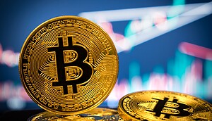 Eine Bitcoin-Münze vor einem Charthintergrund