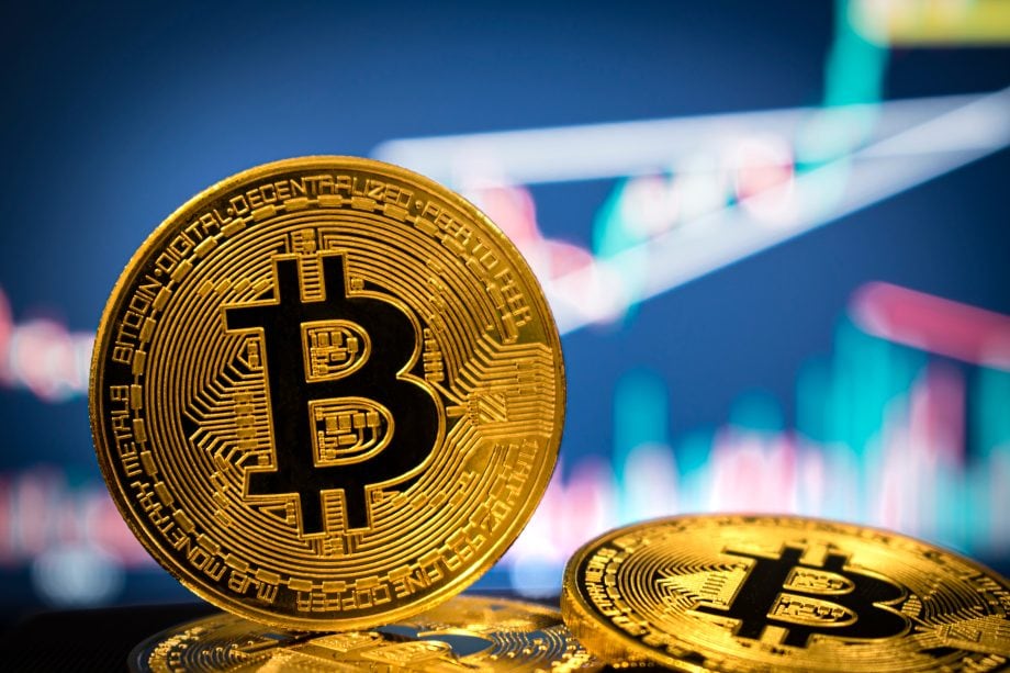 Eine Bitcoin-Münze vor einem Charthintergrund
