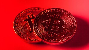 Zwei Bitcoin-Münzen vor rotem Hintergrund