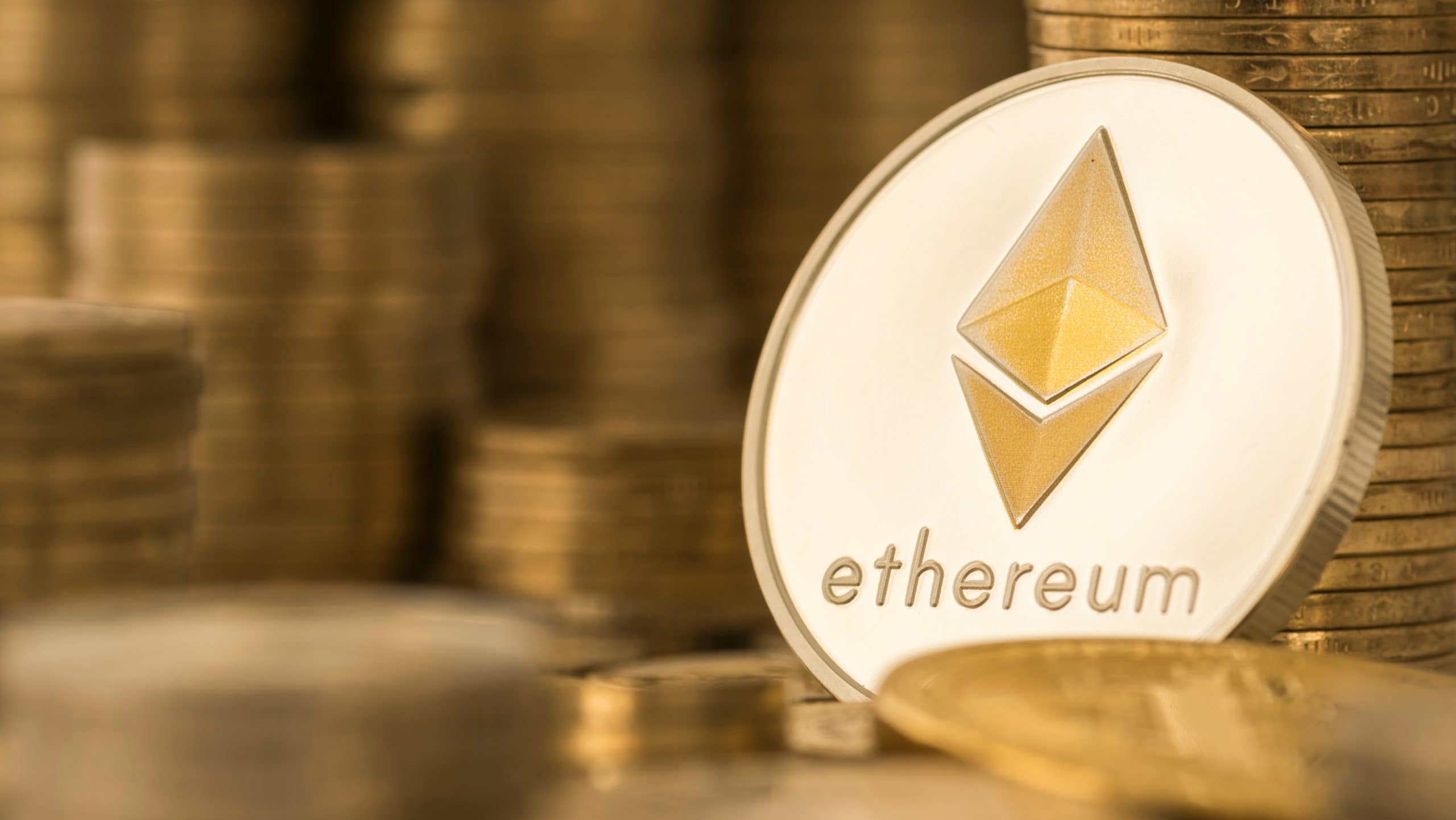 Ethereum-Münze zwischen einem Stapel an goldenen Münzen