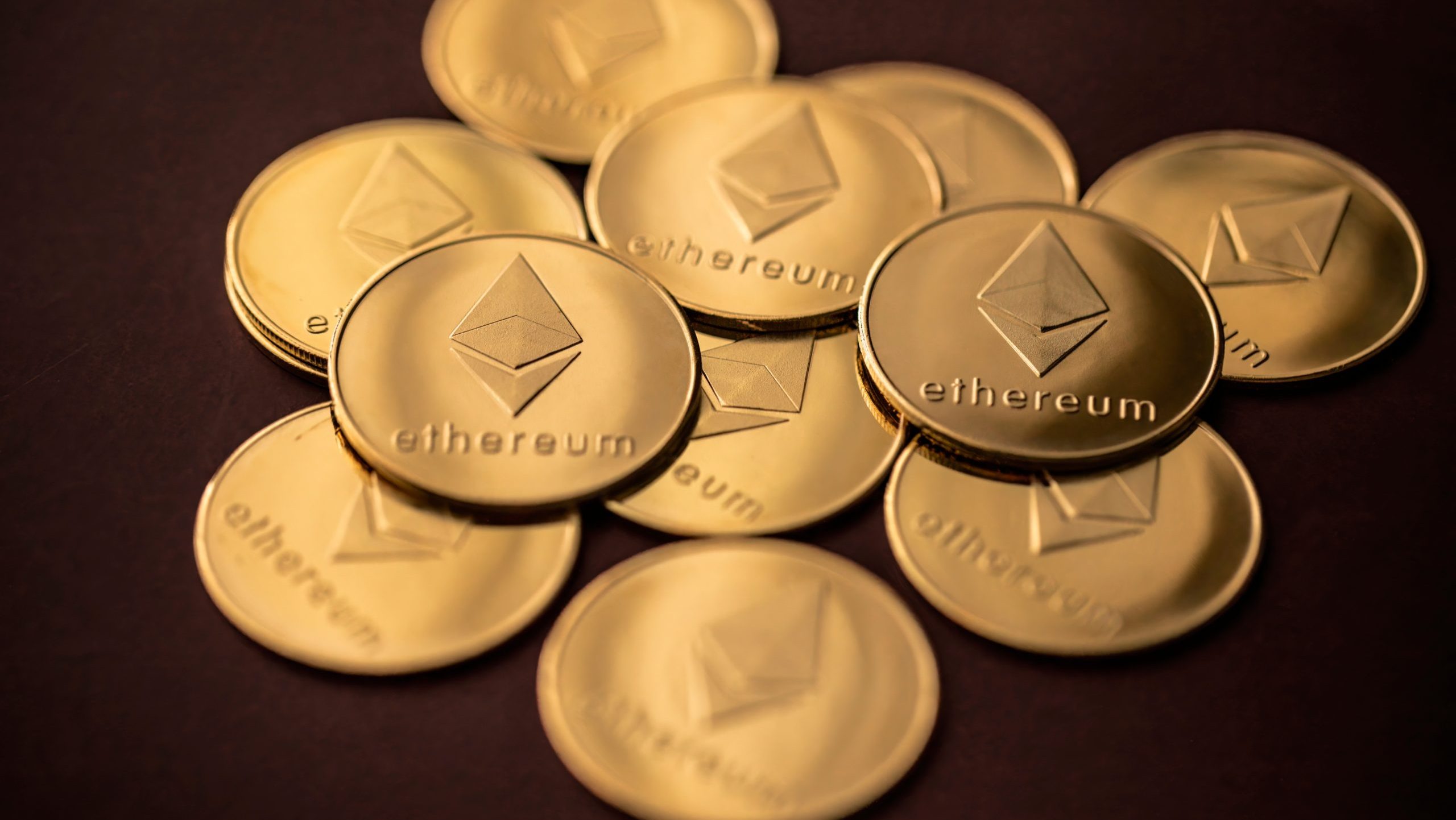 ETH-Münzen verteilt auf einem dunklen, leicht roten Hintergrund