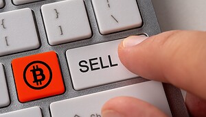 Ein Finger drückt auf die Taste einer Tastatur, auf der "sell" steht