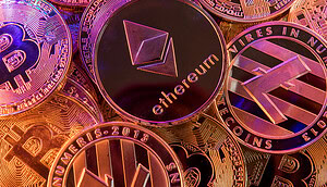 Mehrere aufeinander und rot ausgeleuchtete Münzen von Kryptowährungen wie Bitcoin und Ethereum