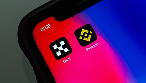 Auf einem Smartphone sieht man die App von OKX neben der Binance App.