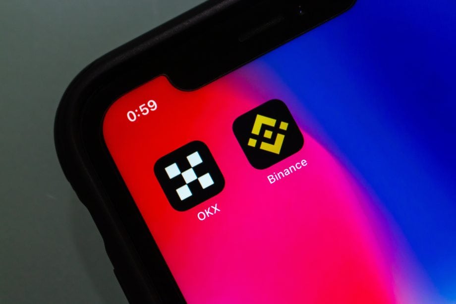 Auf einem Smartphone sieht man die App von OKX neben der Binance App.