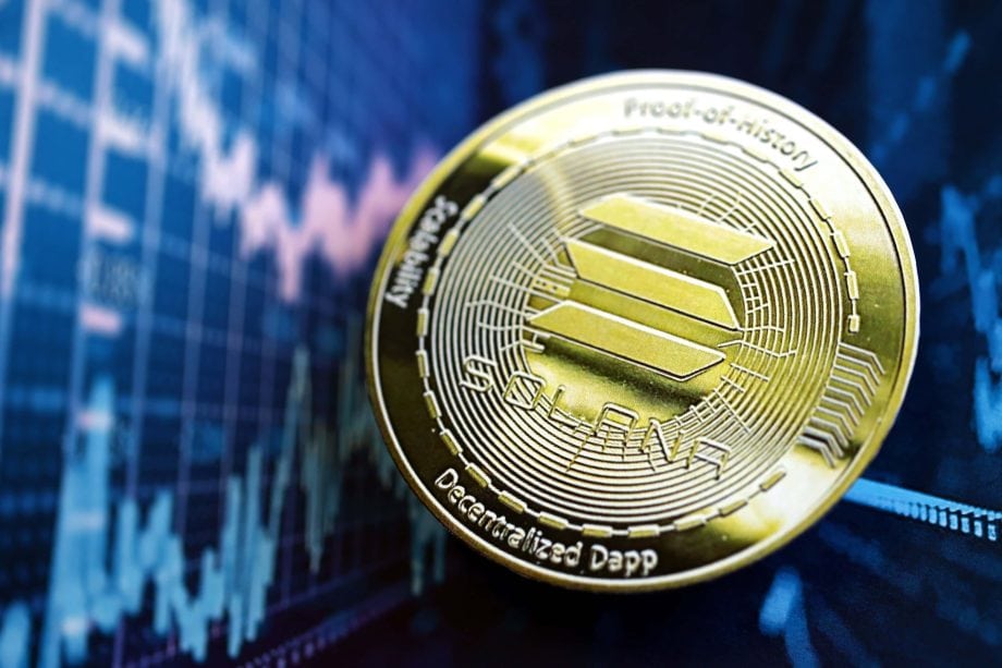 Eine glänzende Solana-Kryptowährungsmünze ruht auf einer Oberfläche, mit einer unscharfen Finanzgrafik im Hintergrund.