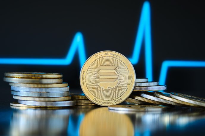 Eine Solana-Münze vor einem blau-schwarzem Chart als Hintergrund