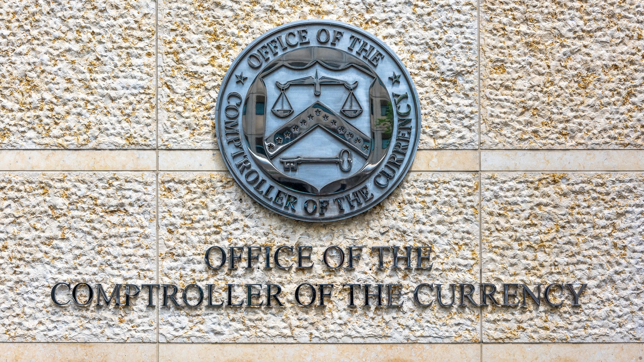 Das Wappen der OCC auf einer hellen Gebäudefassade