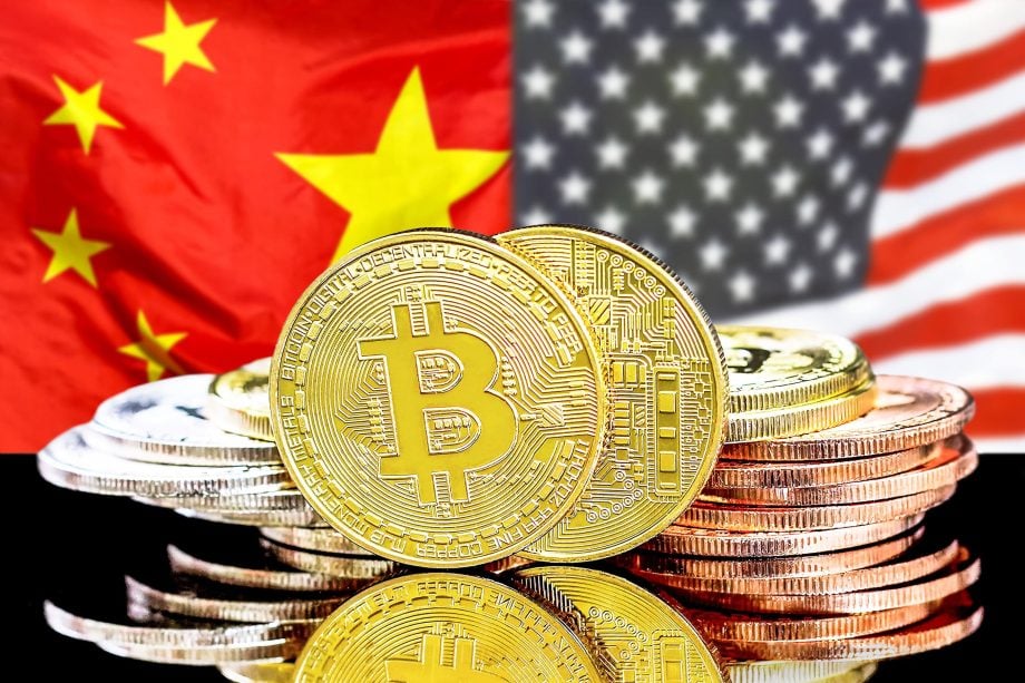 Stapel physischer Bitcoin-Münzen vor den Nationalflaggen Chinas und der Vereinigten Staaten, die den Einfluss von Bitcoin auf die Kryptowährung und das internationale Finanzwesen symbolisieren.