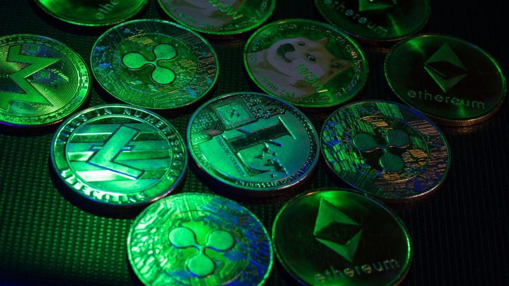 Altcoins mit verborgener Stärke Grün beleuchtete Krypto-Münzen nebeneinander angerichtet