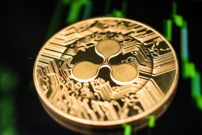 Eine XRP-Münze vor einem grünen Chart als Hintergrund