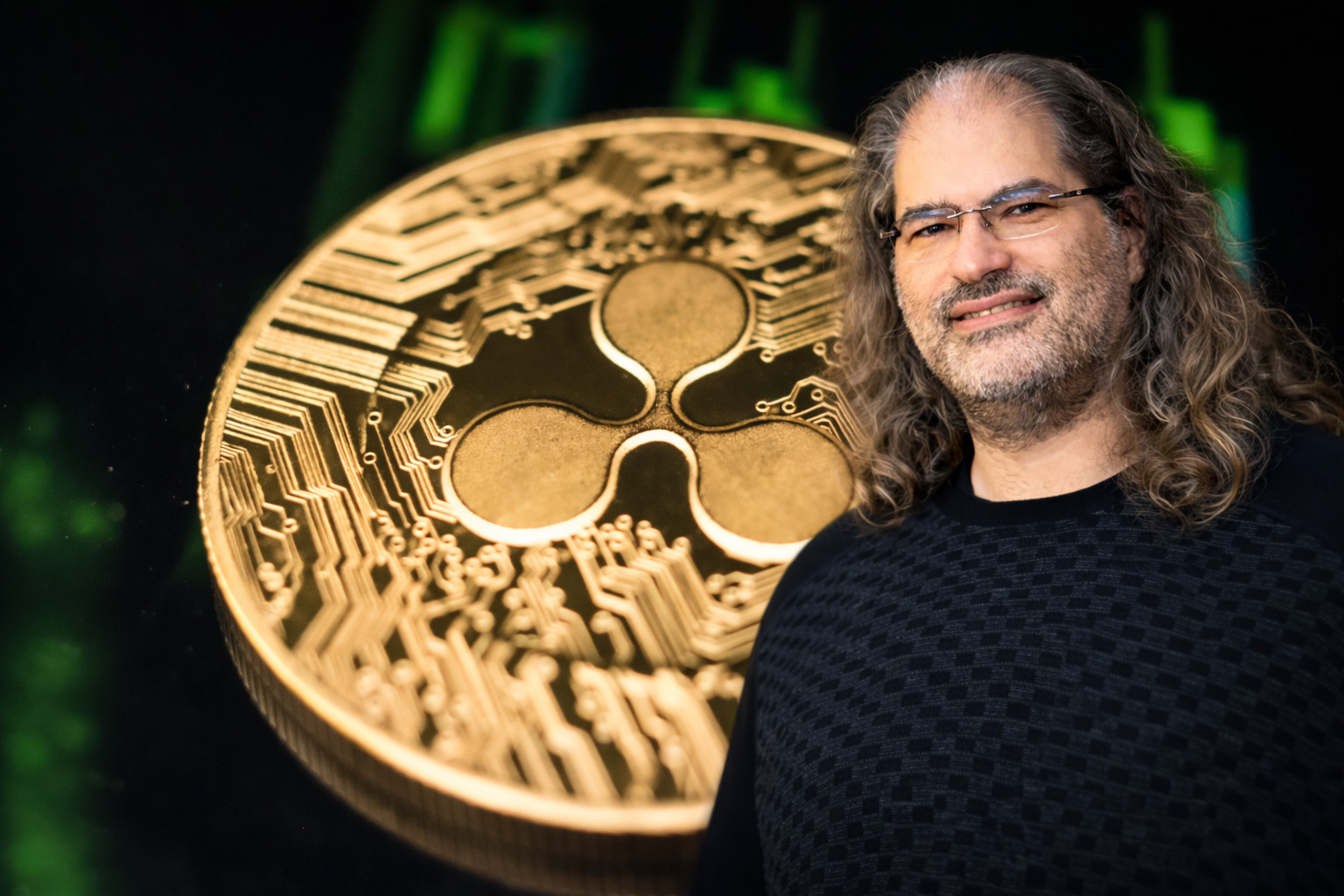 David Schwartz vor XRP-Coin mit grünem Kurschart im Hintergrund.