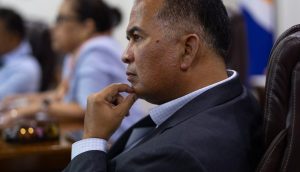 Bedingungsloses Grundeinkommen auf den Marshallinseln: Finanzminister David Paul sitzt in einem Sitzungsraum vor der Flagge des Inselstaats