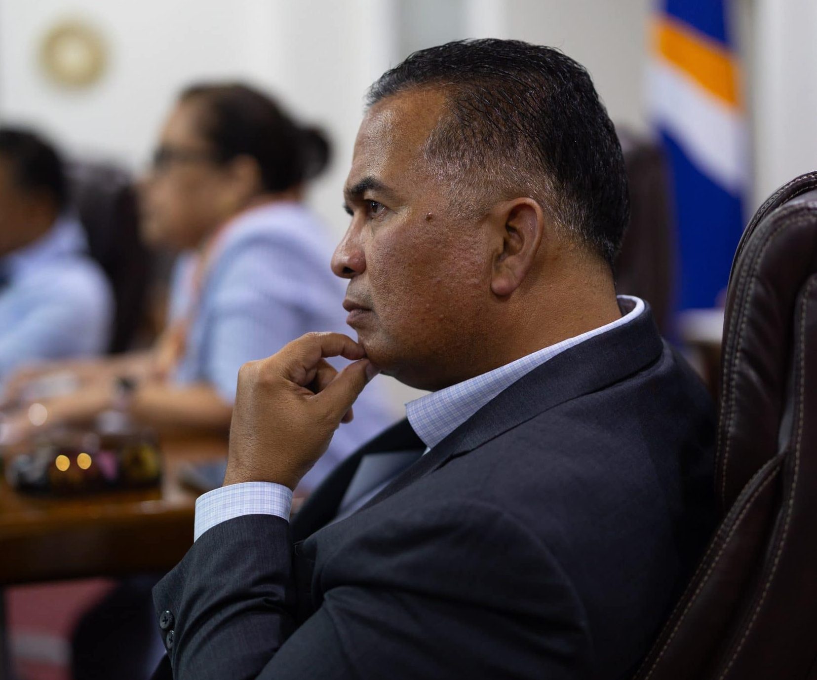 Bedingungsloses Grundeinkommen auf den Marshallinseln: Finanzminister David Paul sitzt in einem Sitzungsraum vor der Flagge des Inselstaats