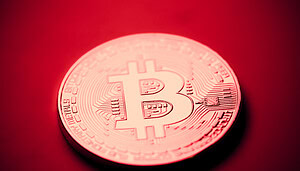 Eine Bitcoin-Münze auf rotem Grund