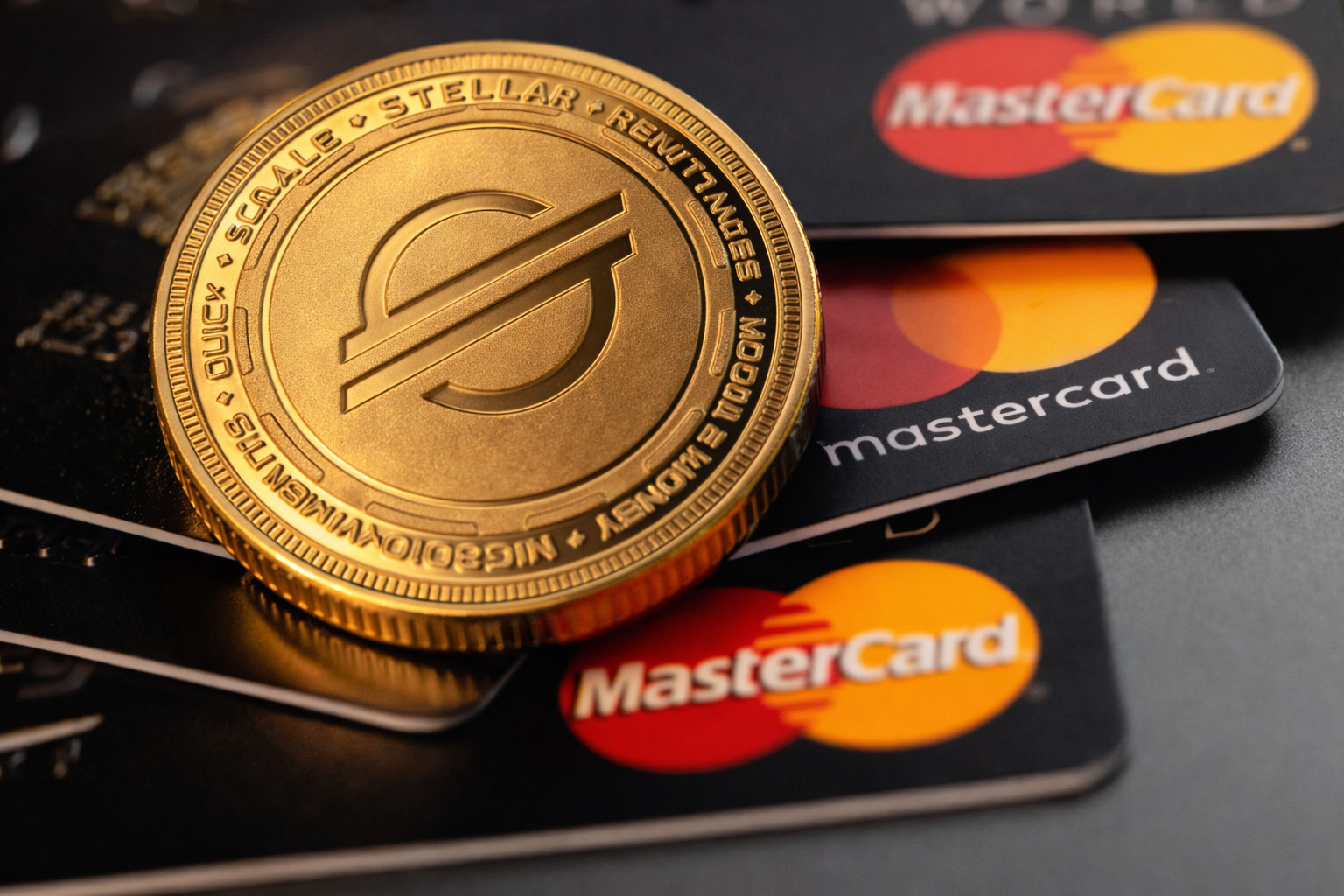 Goldene Stellar-Münze auf mehreren Mastercard-Karten als Symbol für Krypto-Integration im Zahlungsverkehr