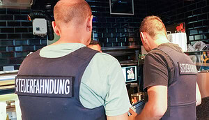 Zwei Männer der Steuerfahndung in einem Geschäft.