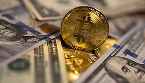 Eine Bitcoin-Münze neben US-Dollar-Banknoten.