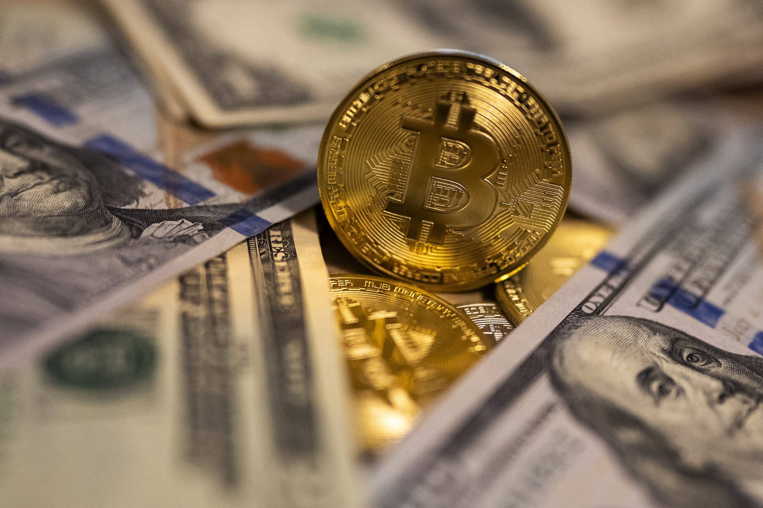 Eine Bitcoin-Münze neben US-Dollar-Banknoten.