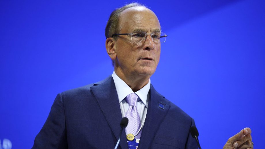 Ein Mann im schwarzem Anzug hinter einem Rednerpult