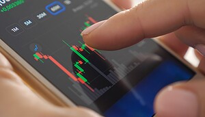 Das Bild zeigt eine Hand, die ein Smartphone hält, auf dem ein Kurschart zu sehen ist