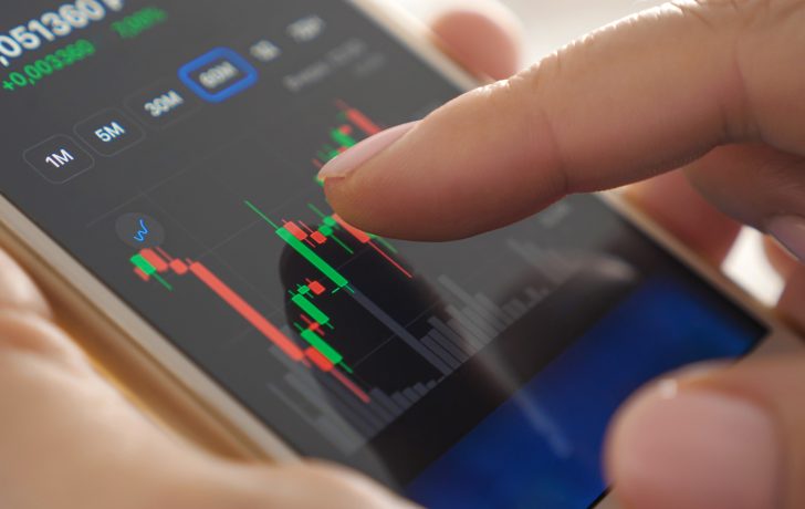 Das Bild zeigt eine Hand, die ein Smartphone hält, auf dem ein Kurschart zu sehen ist