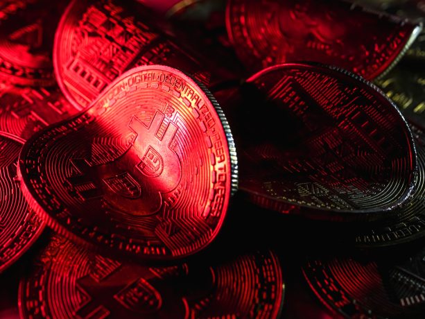 Eine rote verbogene Bitcoin-Münze