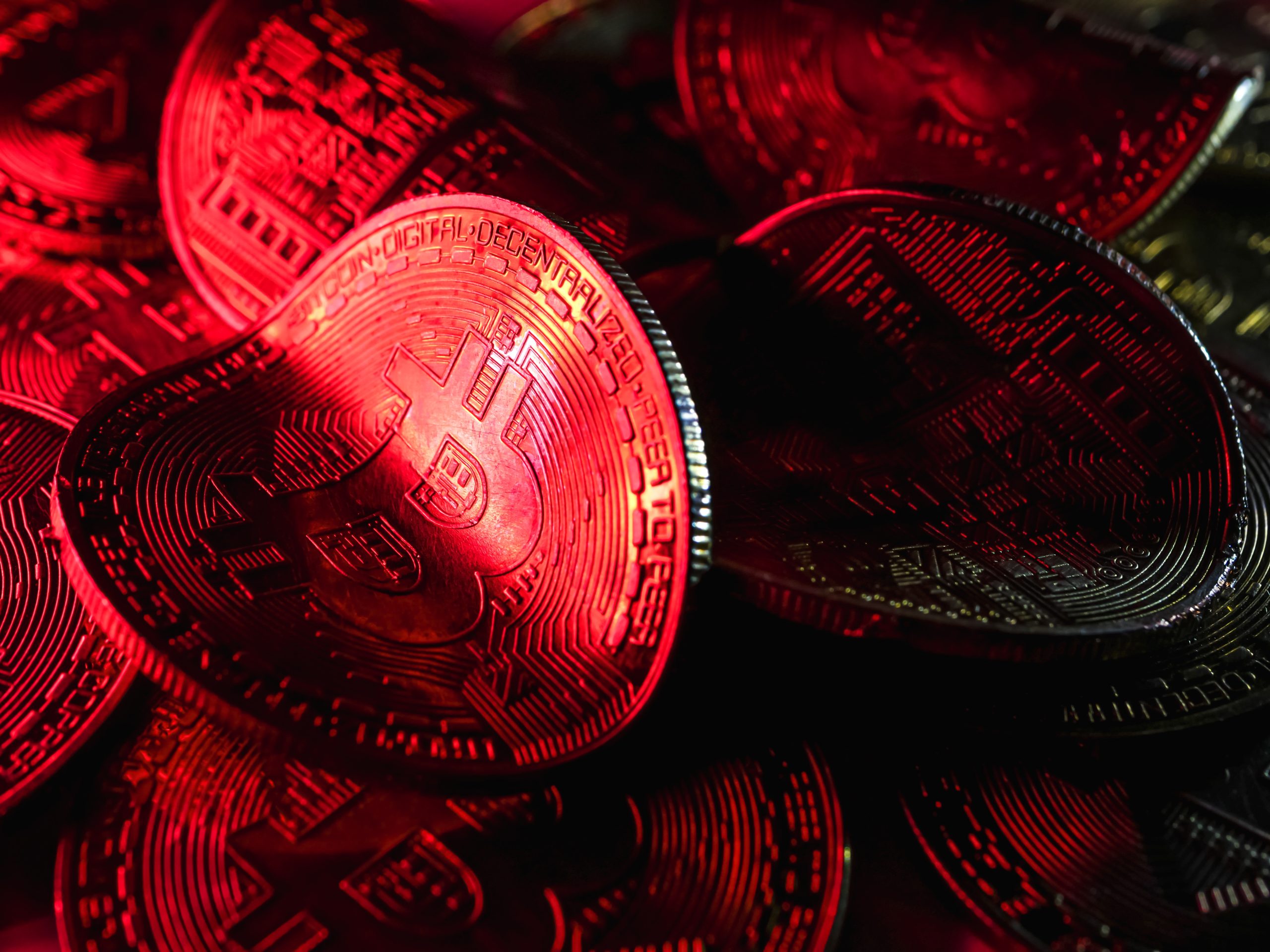 Eine rote verbogene Bitcoin-Münze