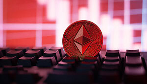 Ethereum-Münze liegt auf Tastatur vor Bildschirm