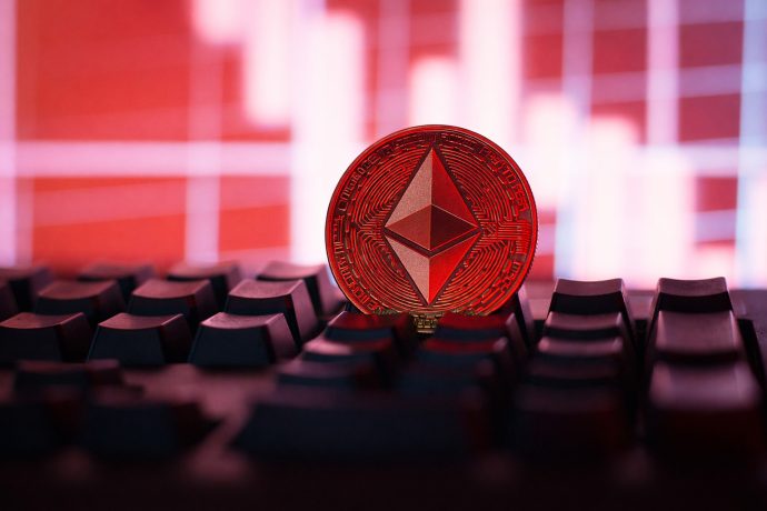 Ethereum-Münze liegt auf Tastatur vor Bildschirm