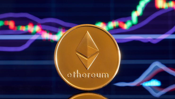 Eine physische Ethereum-Münze steht aufrecht vor einem digitalen Bildschirm, der schwankende Ethereum-Finanzcharts anzeigt.
