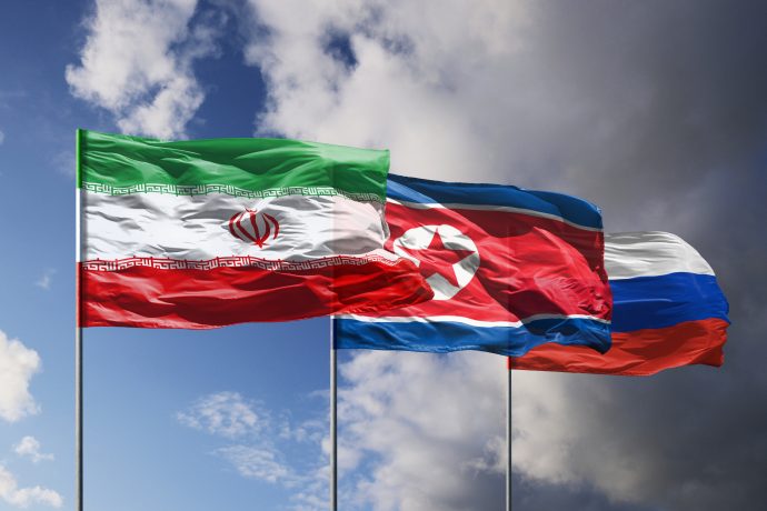 Drei Flaggen wehen im Wind: die iranische, nordkoreanische und russische.