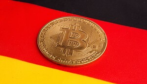 Eine Bitcoin-Münze vor einer Deutschlandflagge