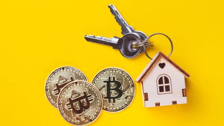 Bitcoin-Münzen und ein Immobilien-Symbol