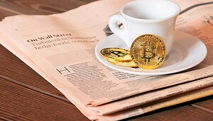 Eine weiße Kaffeetasse steht auf einer Untertasse auf einer Zeitung, daneben liegen zwei physische Bitcoin-Münzen und ein Hauch von Krypto-Intrige.