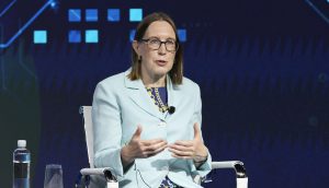 Eine Frau im hellen Wrack bei einer Rede auf einer Konferenz