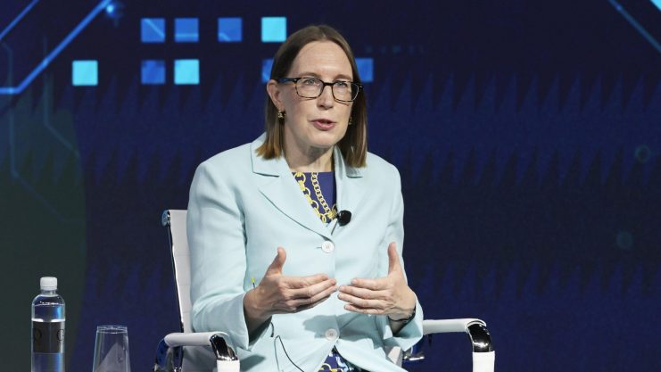 Eine Frau im hellen Wrack bei einer Rede auf einer Konferenz