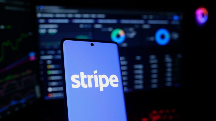 tempo-blockchain-von-stripe Das Stripe-Logo auf einem Smartphone vor dem Hintergrund eines Bildschirms mit Daten und Analysen