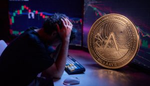 Ein frustrierter Trader vor Bildschirmen mit einer Aave-Münze davor