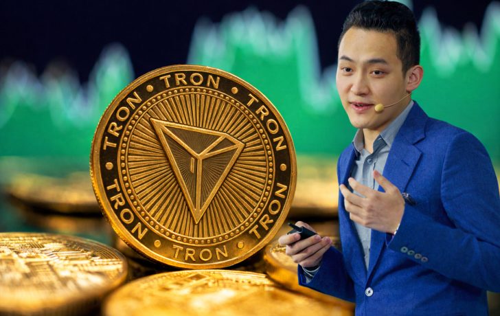 Tron-Gründer Justin Sun vor einer großen TRX-Münze mit Kursgrafik im Hintergrund.