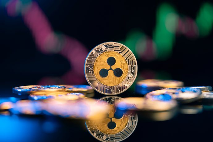 XRP-Münze vor durchwachsenem Chartbild