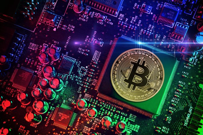 Eine Bitcoin-Münze auf einem Motherboard eines Computers.