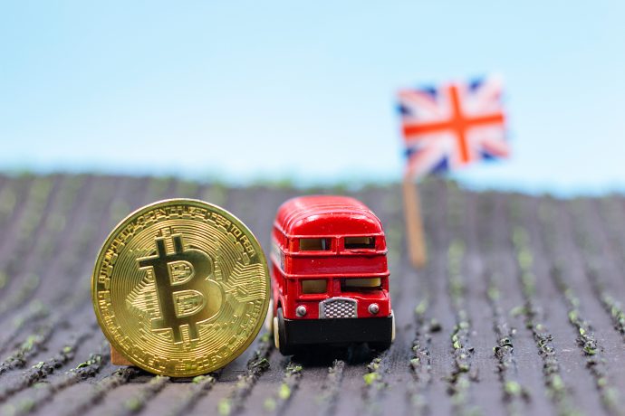 Das Bild zeigt eine Bitcoin-Münze neben einem Bus