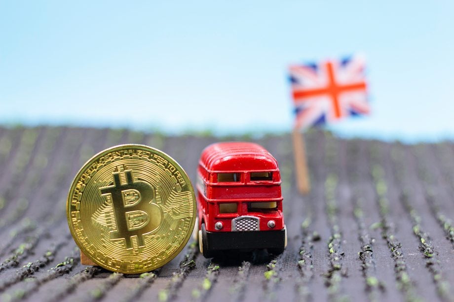 Das Bild zeigt eine Bitcoin-Münze neben einem Bus