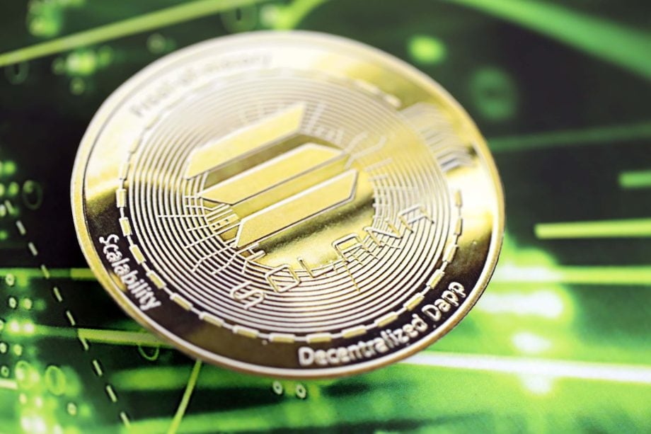 Das Bild zeigt eine große Solana-Münze mit grünem Hintergrund.