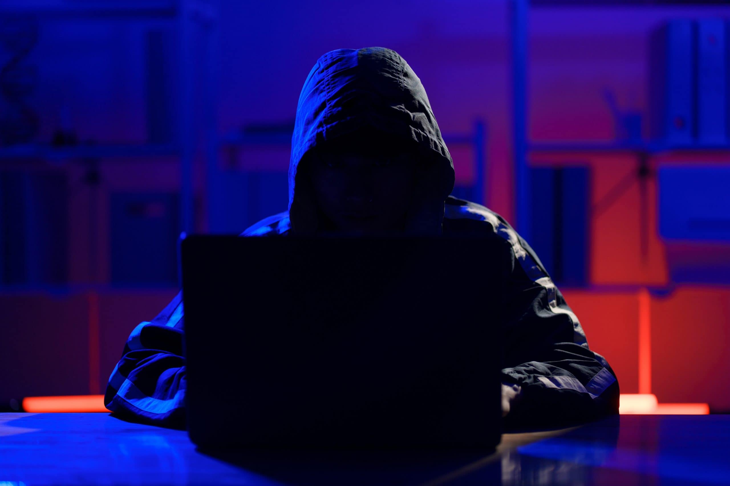 Das Bild zeigt eine Hacker vor einem Laptop