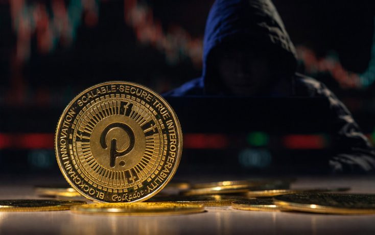 Verschwommene, kapuzenbewehrte Person sitzt im Hintergrund vor einem Laptop, während im Vordergrund eine scharf fokussierte Polkadot-Kryptowährungs-Münze mit einem Kursdiagramm dahinter zu sehen ist.