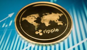 Eine Nahaufnahme einer goldenen Ripple (XRP)-Kryptowährungsmünze mit einem Weltkartenmotiv auf blauem Hintergrund mit Finanzdiagrammlinien.